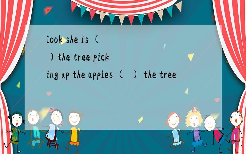 look she is ( )the tree picking up the apples ( ) the tree